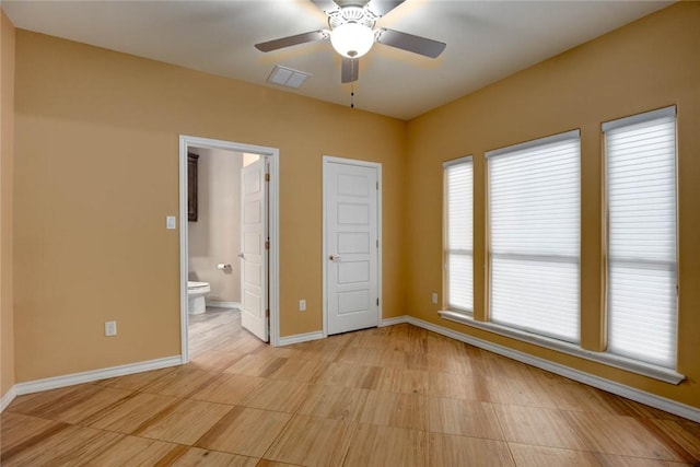 unfurnished bedroom featuring ceiling fan, connected bathroom, visible vents, and baseboards