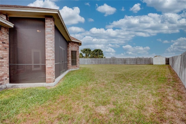 view of yard featuring an outbuilding, a sunroom, a fenced backyard, and a shed