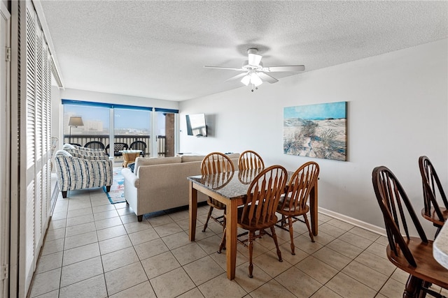 dining space with a textured ceiling, ceiling fan, and light tile patterned floors