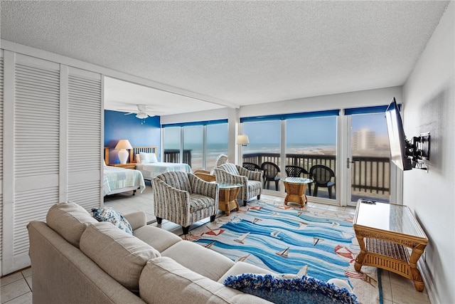 tiled living room with a textured ceiling and ceiling fan