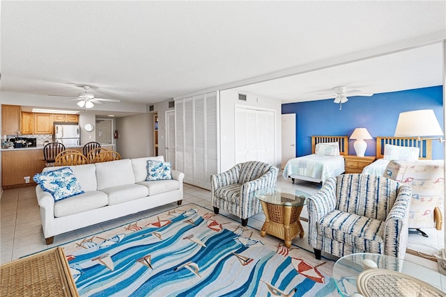 tiled bedroom with a textured ceiling, ceiling fan, and white refrigerator