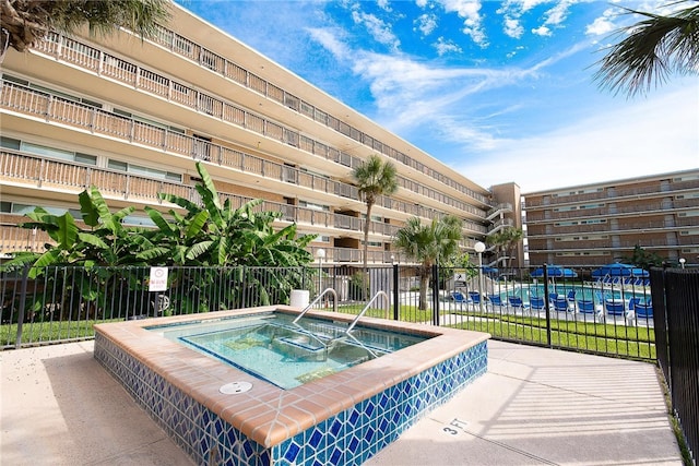 view of swimming pool featuring a hot tub