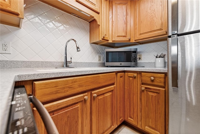 kitchen featuring stainless steel appliances, sink, and decorative backsplash