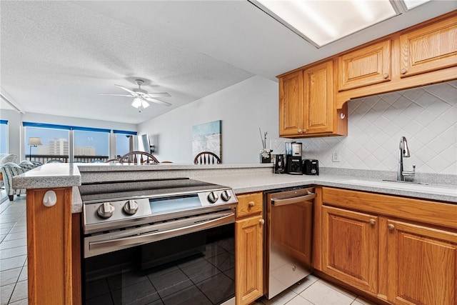 kitchen featuring stainless steel appliances, backsplash, light tile patterned floors, sink, and kitchen peninsula