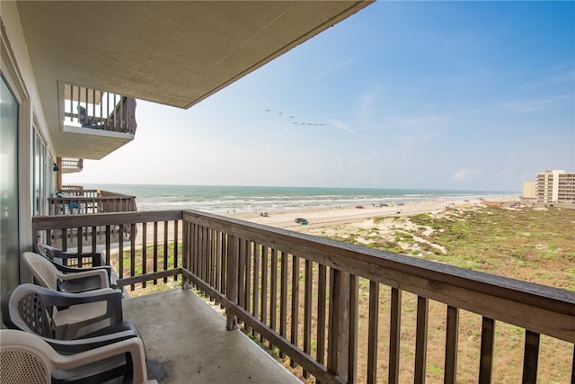 balcony featuring a view of the beach and a water view