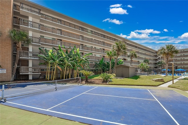 view of tennis court featuring a shed