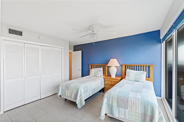 bedroom featuring light tile patterned floors, ceiling fan, and a closet