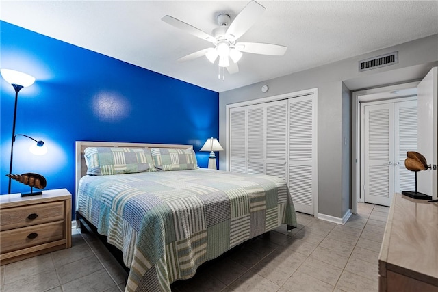 bedroom featuring a textured ceiling, a closet, ceiling fan, and light tile patterned floors