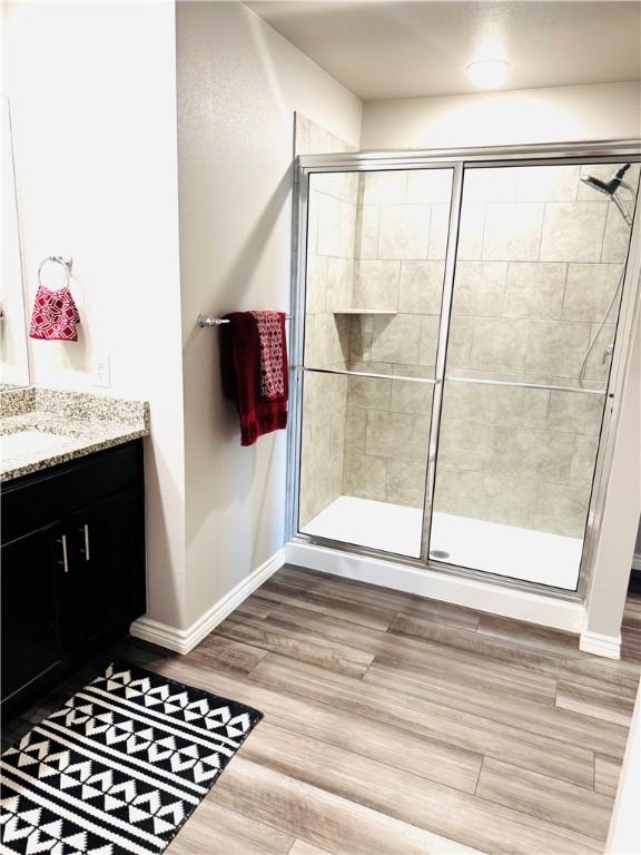1353 Regents Park Ln, Corpus Christi, TX 78415 - bathroom featuring a shower stall, baseboards, vanity, and wood finished floors