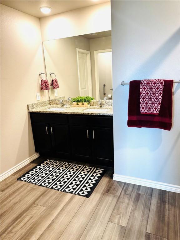 1353 Regents Park Ln, Corpus Christi, TX 78415 - full bath featuring wood finished floors, baseboards, and double vanity