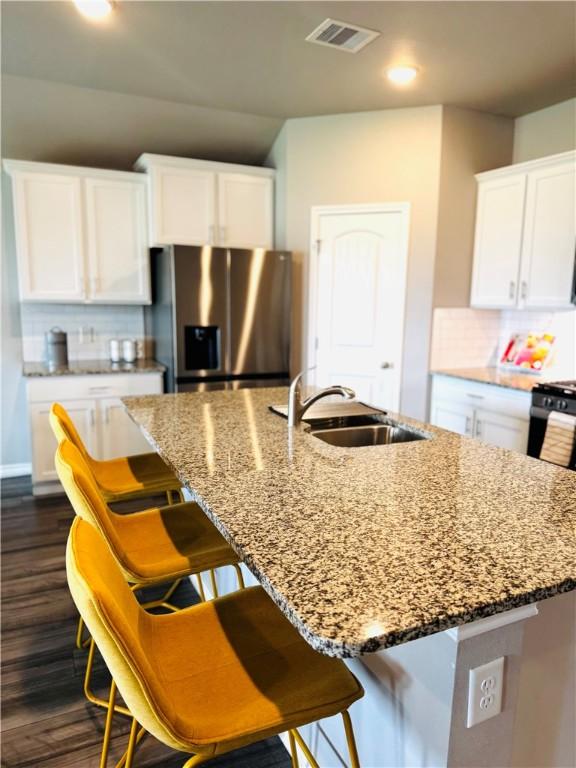 1353 Regents Park Ln, Corpus Christi, TX 78415 - kitchen with stainless steel fridge with ice dispenser, a sink, stone counters, a center island with sink, and recessed lighting