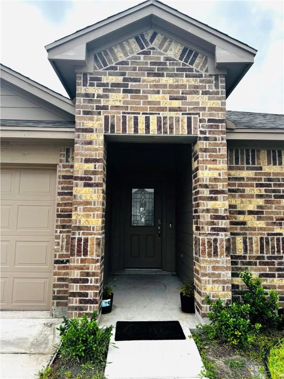 1353 Regents Park Ln, Corpus Christi, TX 78415 - doorway to property with brick siding and an attached garage