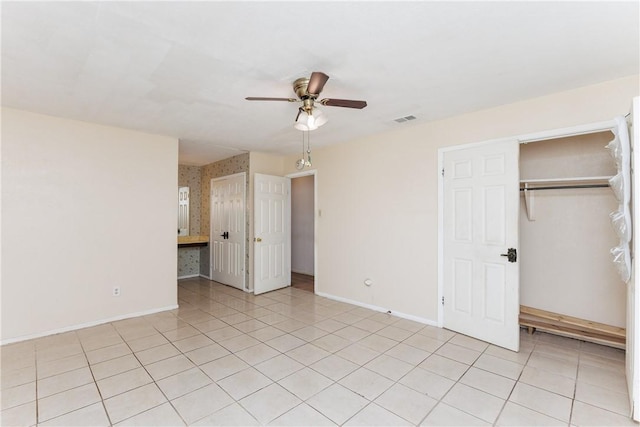 interior space with light tile patterned floors, ceiling fan, and a closet