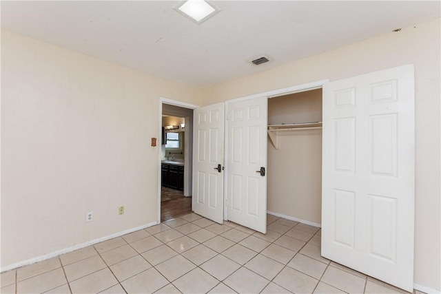 unfurnished bedroom featuring light tile patterned floors and a closet