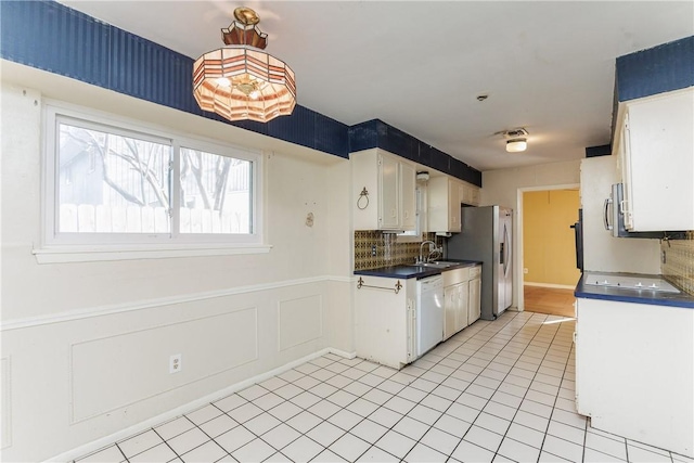 kitchen with white cabinetry, stainless steel appliances, decorative backsplash, and light tile patterned floors