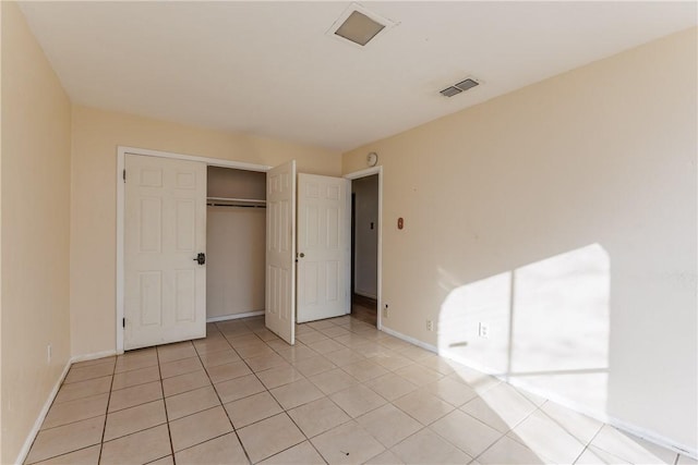 unfurnished bedroom featuring light tile patterned flooring and a closet