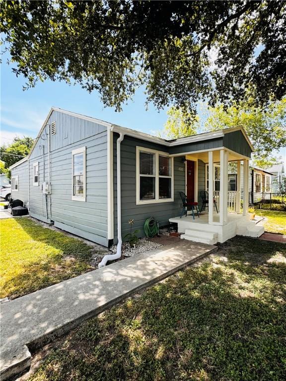 exterior space featuring covered porch and a front yard