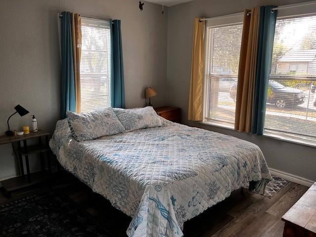 bedroom with dark wood-type flooring