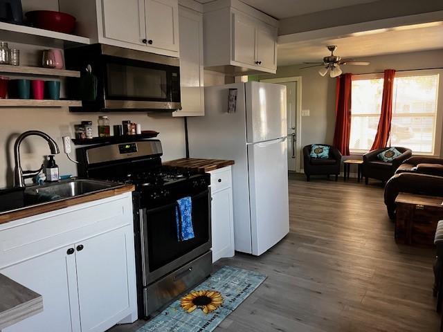 kitchen with white cabinets, sink, wood-type flooring, and stainless steel appliances