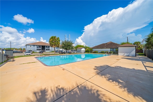 view of pool with a patio area and an outdoor structure