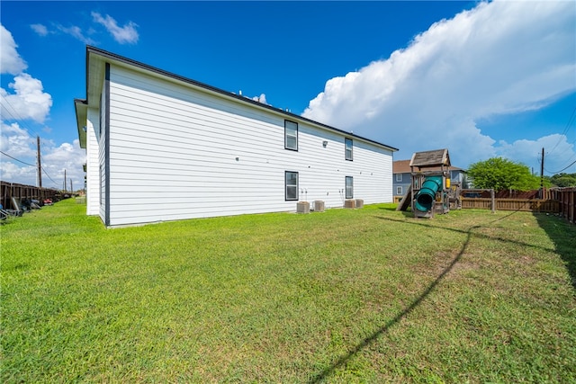 back of house with a lawn and a playground