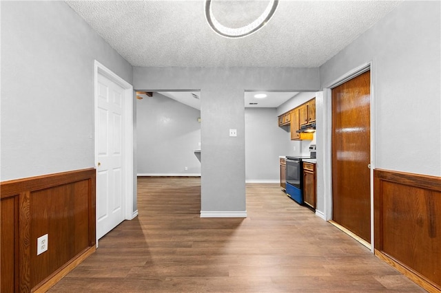 interior space featuring hardwood / wood-style flooring, range with electric stovetop, and a textured ceiling