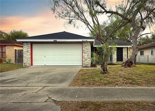 ranch-style home featuring a garage and a yard