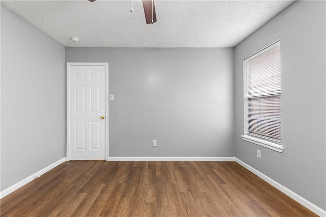 empty room featuring a textured ceiling and dark wood-type flooring