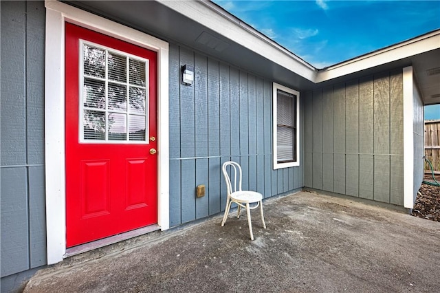 view of exterior entry with a patio area