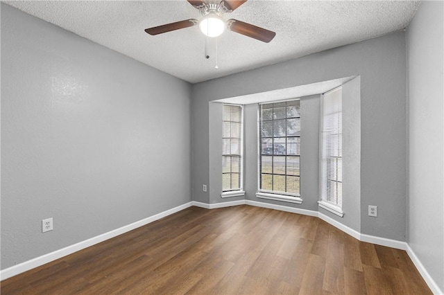 empty room with hardwood / wood-style flooring, ceiling fan, and a textured ceiling