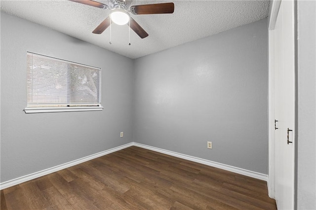 empty room with a textured ceiling, dark hardwood / wood-style floors, and ceiling fan