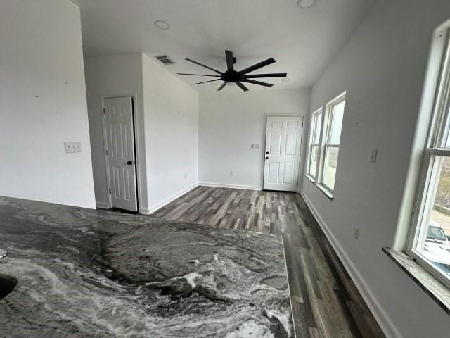 unfurnished living room featuring dark wood finished floors, visible vents, and baseboards