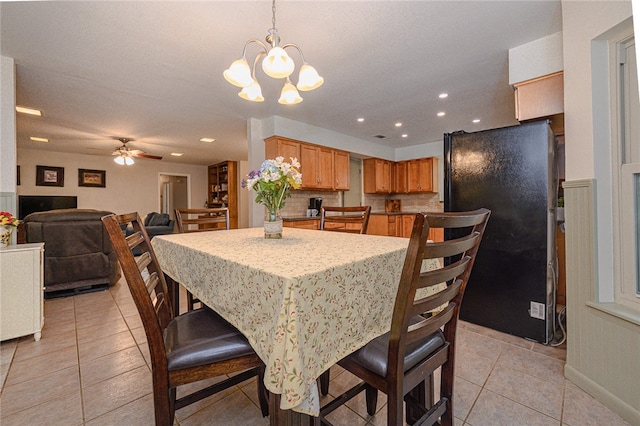 dining room featuring ceiling fan with notable chandelier and light tile patterned floors