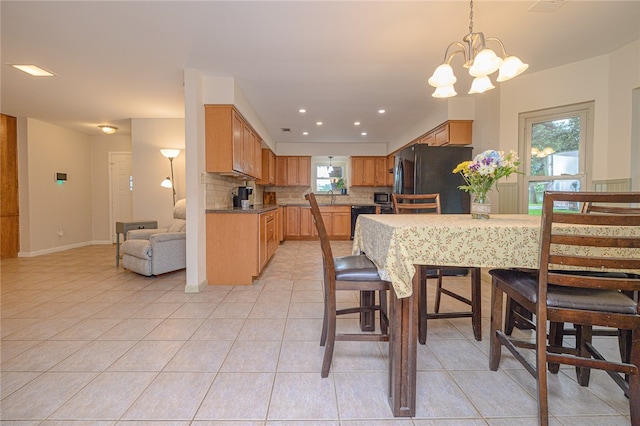 tiled dining room featuring sink and an inviting chandelier