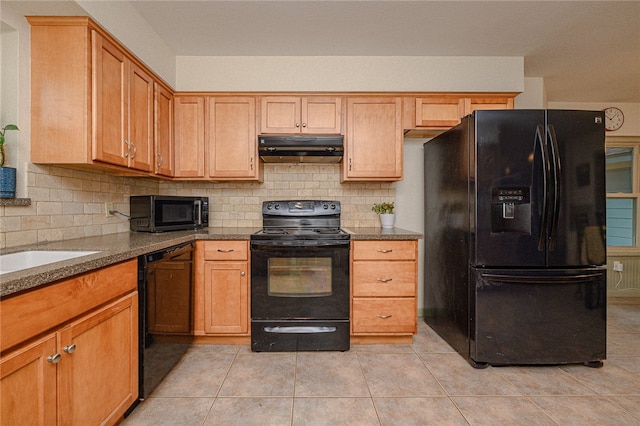 kitchen with black appliances, stone counters, light tile patterned floors, sink, and backsplash