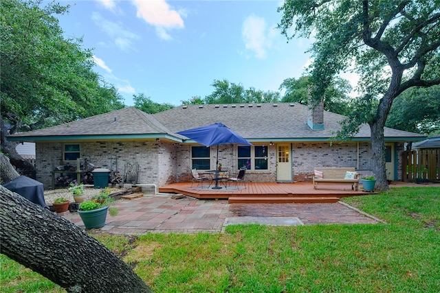 rear view of property with a lawn and a wooden deck