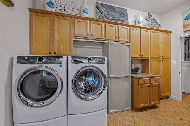 laundry room with cabinets, light tile patterned floors, and independent washer and dryer