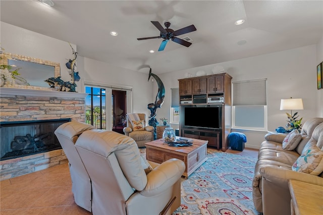 tiled living room with a fireplace and ceiling fan