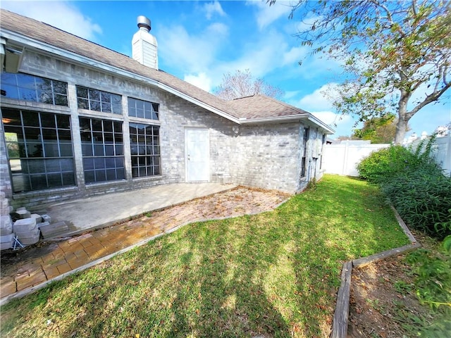 rear view of property featuring a yard and a patio