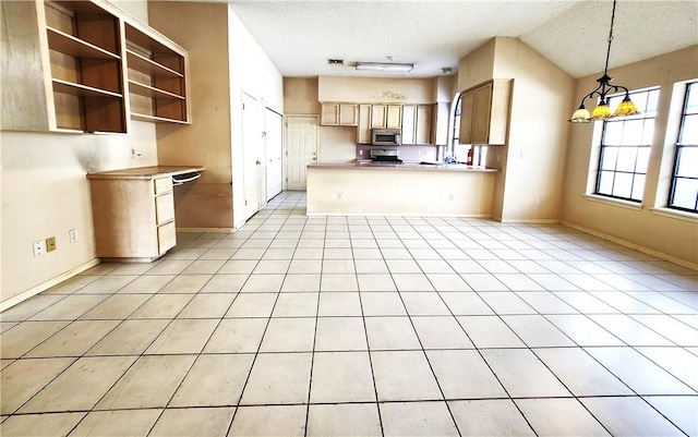 2210 Dorsey St, Corpus Christi, TX 78414 - kitchen with stainless steel microwave, a textured ceiling, a peninsula, open floor plan, and pendant lighting