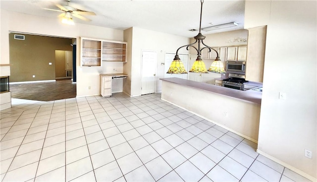 kitchen featuring ceiling fan, hanging light fixtures, light tile patterned flooring, and stainless steel appliances