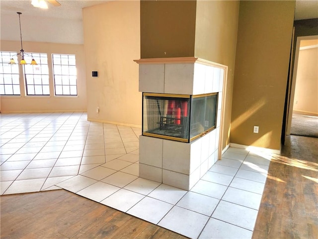 2210 Dorsey St, Corpus Christi, TX 78414 - unfurnished living room featuring a multi sided fireplace, a chandelier, and light wood-style flooring