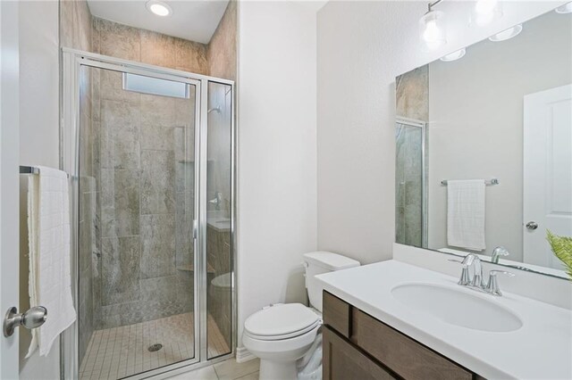 bathroom featuring tile patterned floors, vanity, toilet, and walk in shower