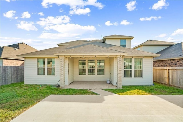 back of property with a yard and a patio