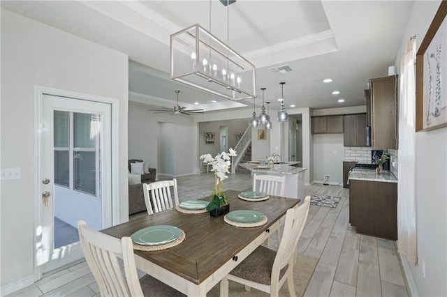 dining room with a tray ceiling and ceiling fan