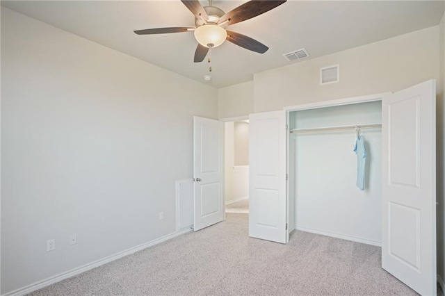 unfurnished bedroom with ceiling fan, a closet, and light carpet