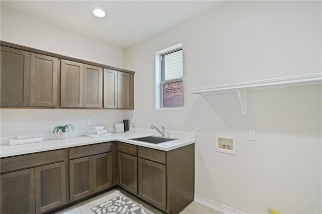 laundry area featuring cabinets, washer hookup, light tile patterned flooring, and sink