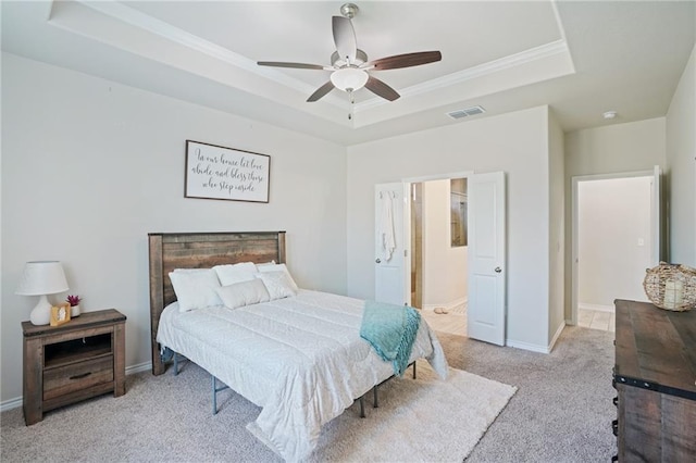 bedroom with light carpet, a tray ceiling, ceiling fan, and crown molding