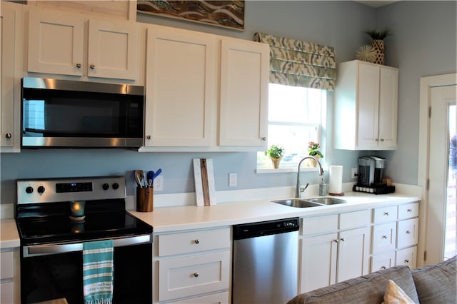 kitchen featuring appliances with stainless steel finishes, white cabinetry, and sink