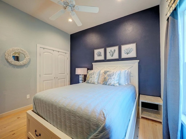 bedroom with ceiling fan, light wood-type flooring, and a closet